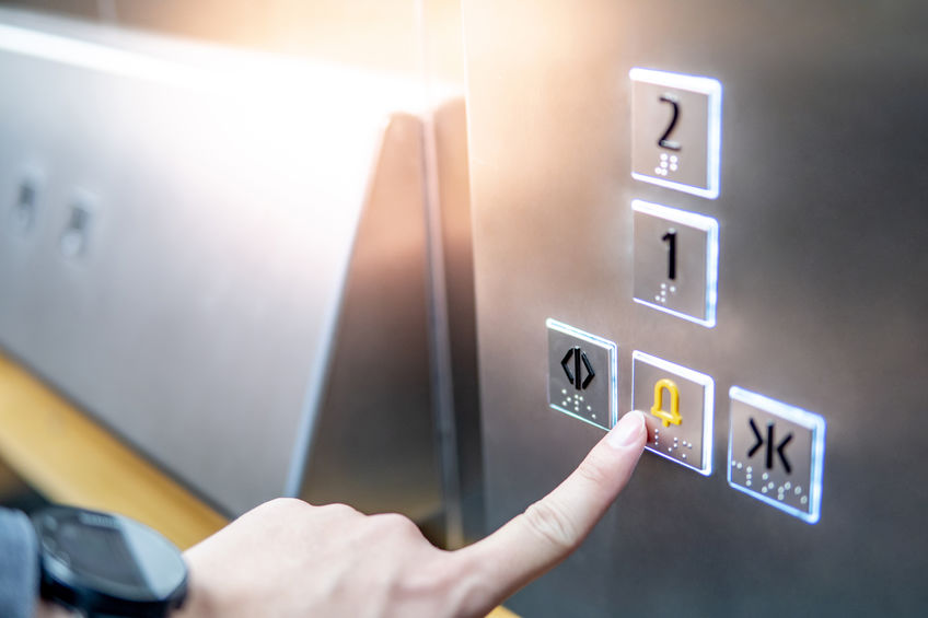 Male hand pressing on emergency button in elevator